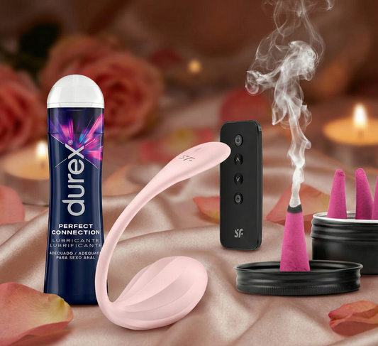 Image de présentation d'un ensemble bien-être composé d'un masseur personnel Satisfyer Wearable rose avec sa télécommande sans fil, d'un flacon de lubrifiant Durex Perfect Connection de 50 ml et de cônes d'encens roses, le tout mis en scène sur un drap de satin avec des pétales de fleurs et des bougies.